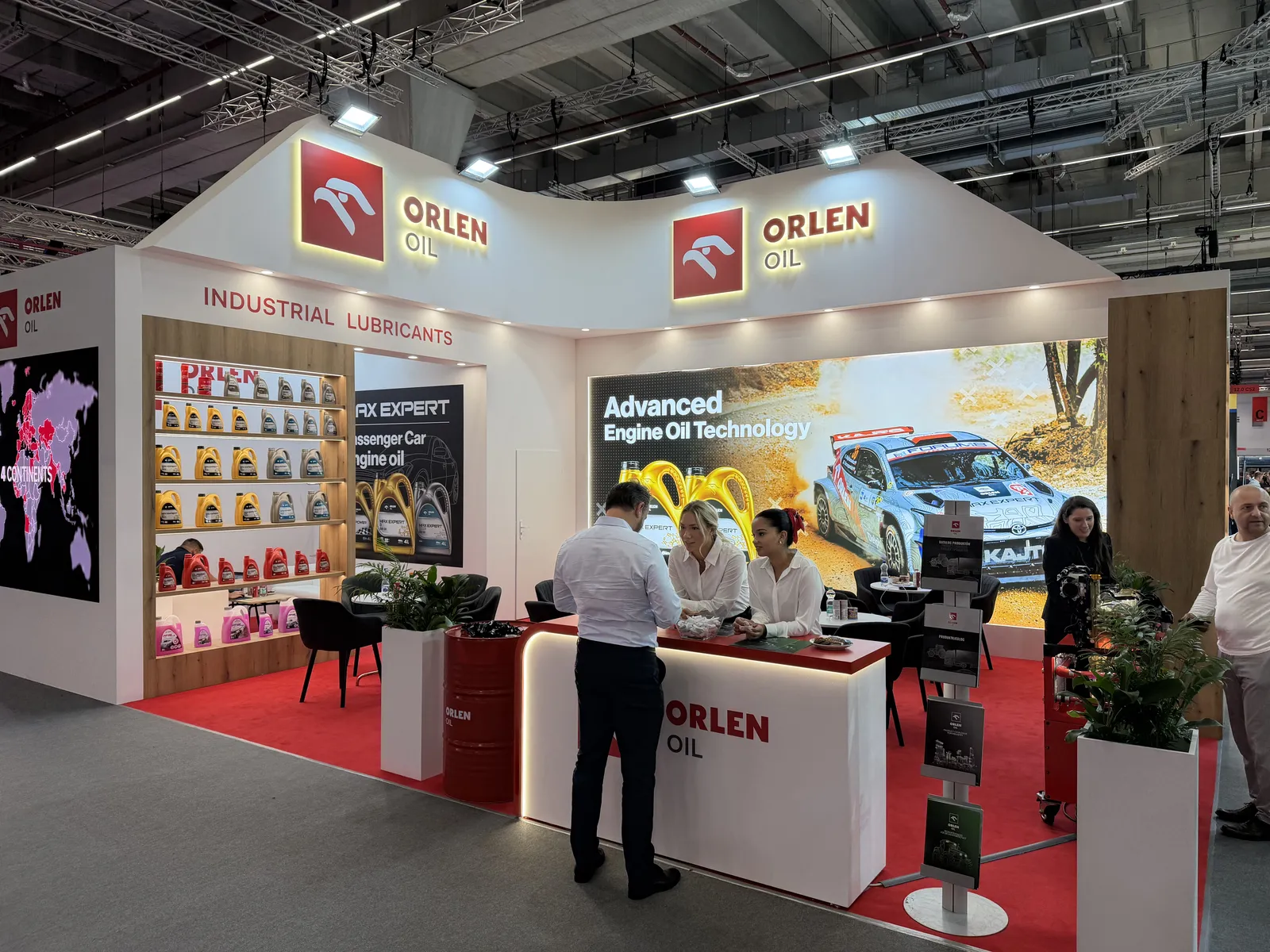 Stoisko ORLEN OIL na Automechanika Frankfurt 2026 z regałem olejów silnikowych, obsługa i zwiedzający przy ladzie